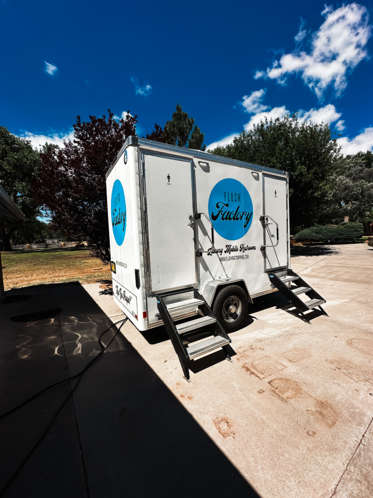 Three-stall luxury restroom trailer with entry steps on a concrete pad