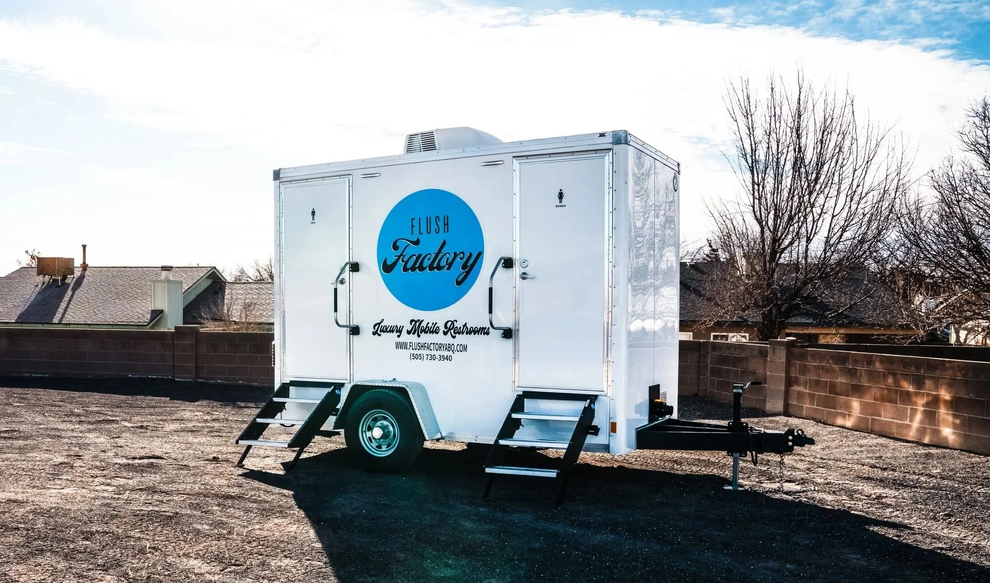 Two-stall Flush Factory restroom trailer with steps set up on site