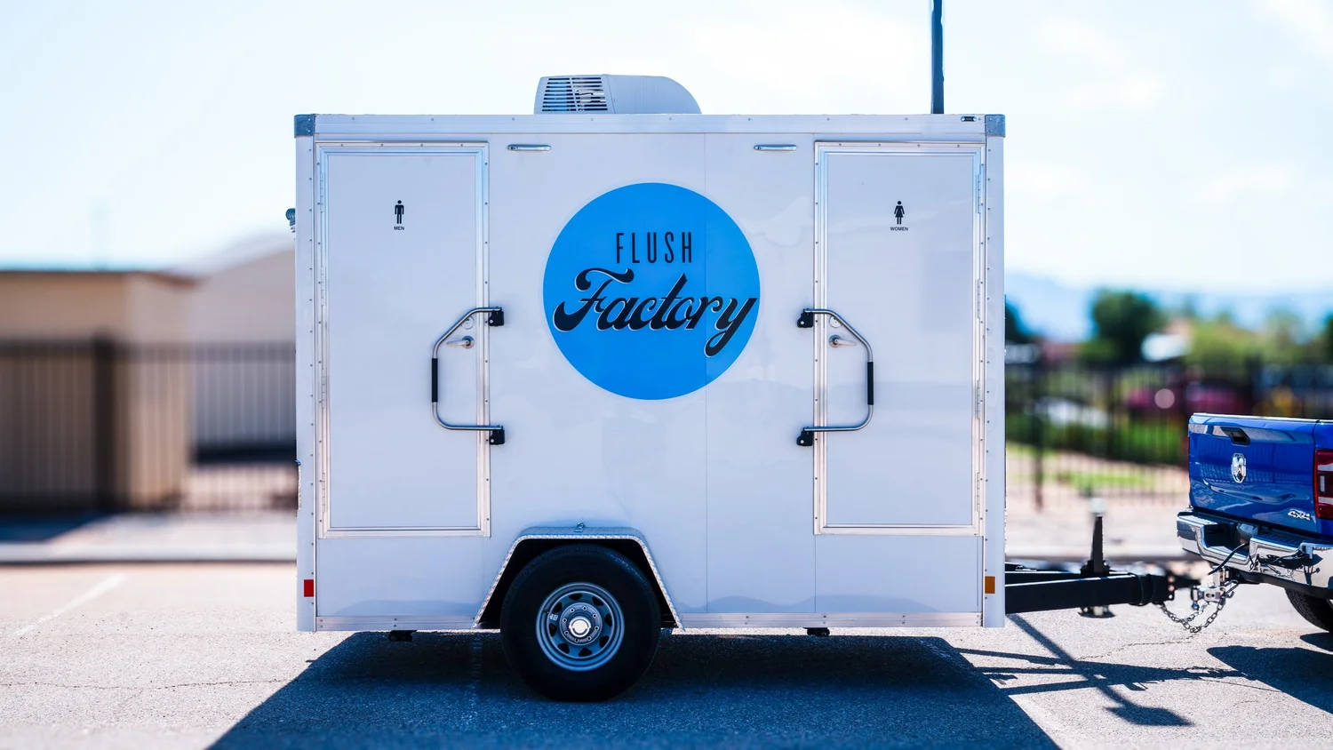Rear view of the Flush Factory restroom trailer with logo